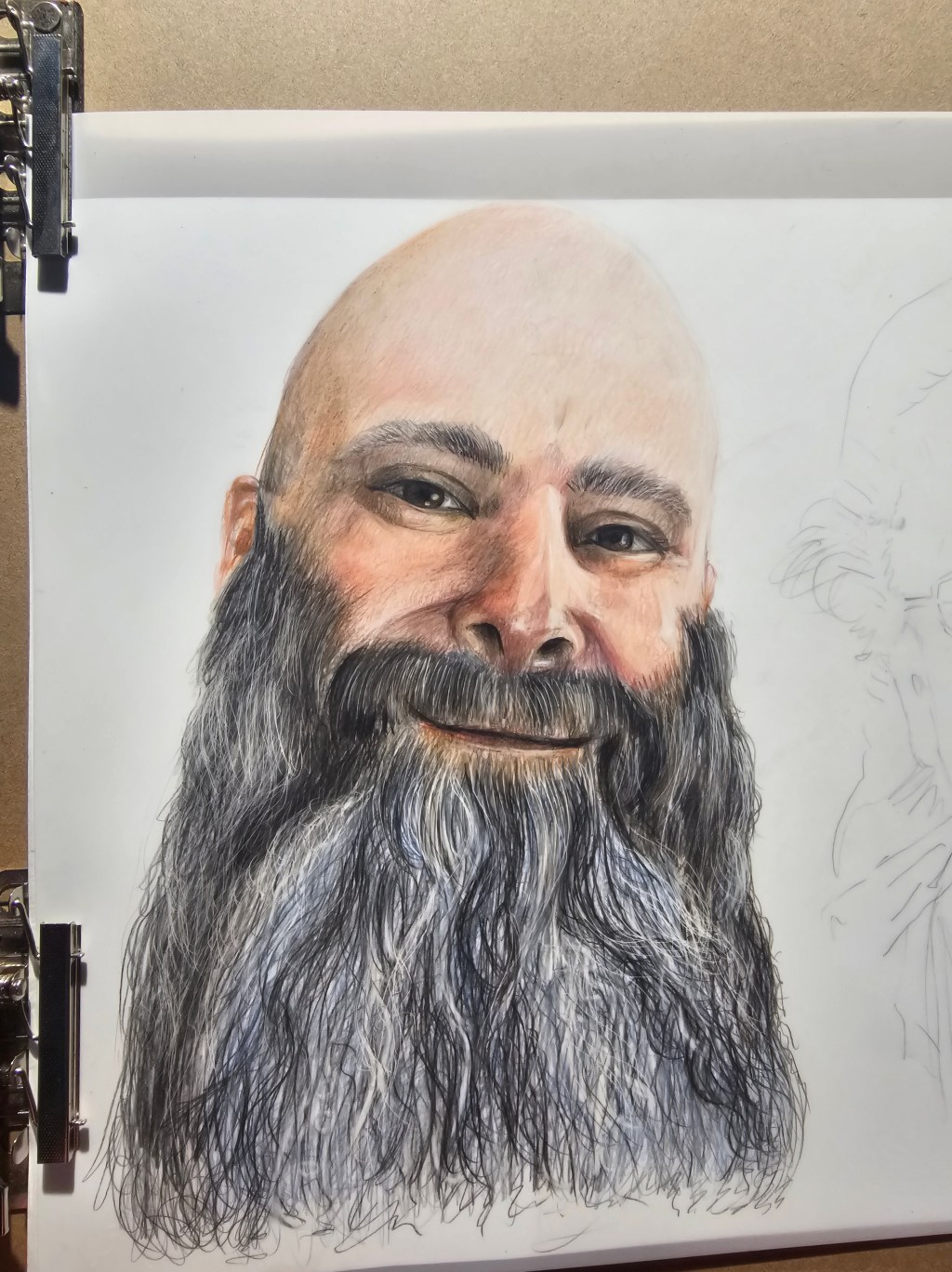 Work-in-progress colored-pencil portrait of a bearded man, showing detailed facial shading and unfinished areas.